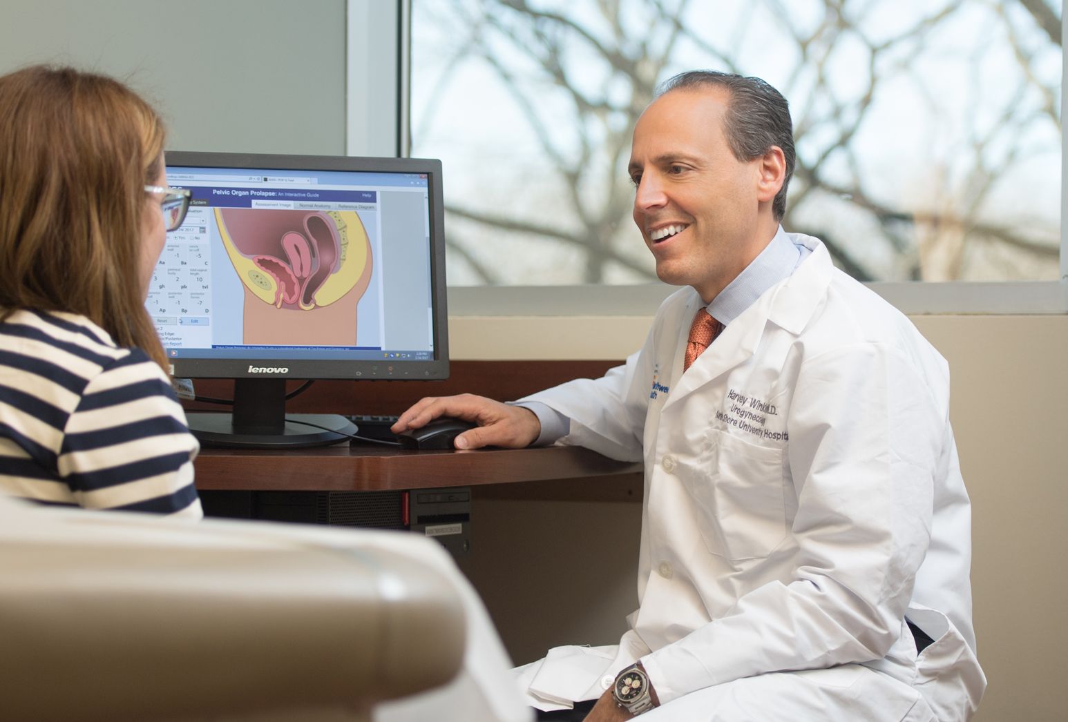 A male doctor smiles at his female patient.